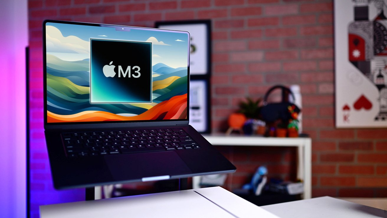 M3 MacBook Air v půlnoci na stole s barevnými tapetami, zobrazující grafiku 'Apple M3', v místnosti se zdí z červených cihel a dekorativními předměty.