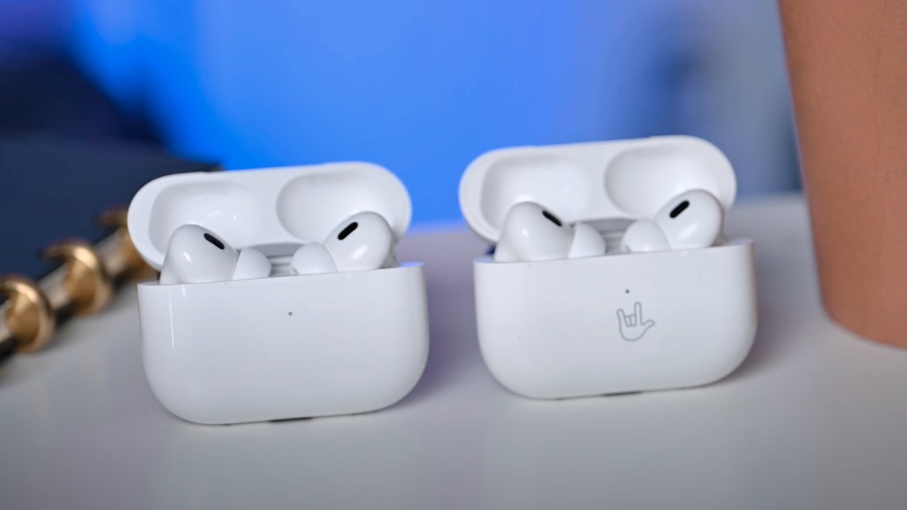 Dva páry sluchátek AirPods Pro v otevřených nabíjecích pouzdrech na rozmazaném modrém pozadí.