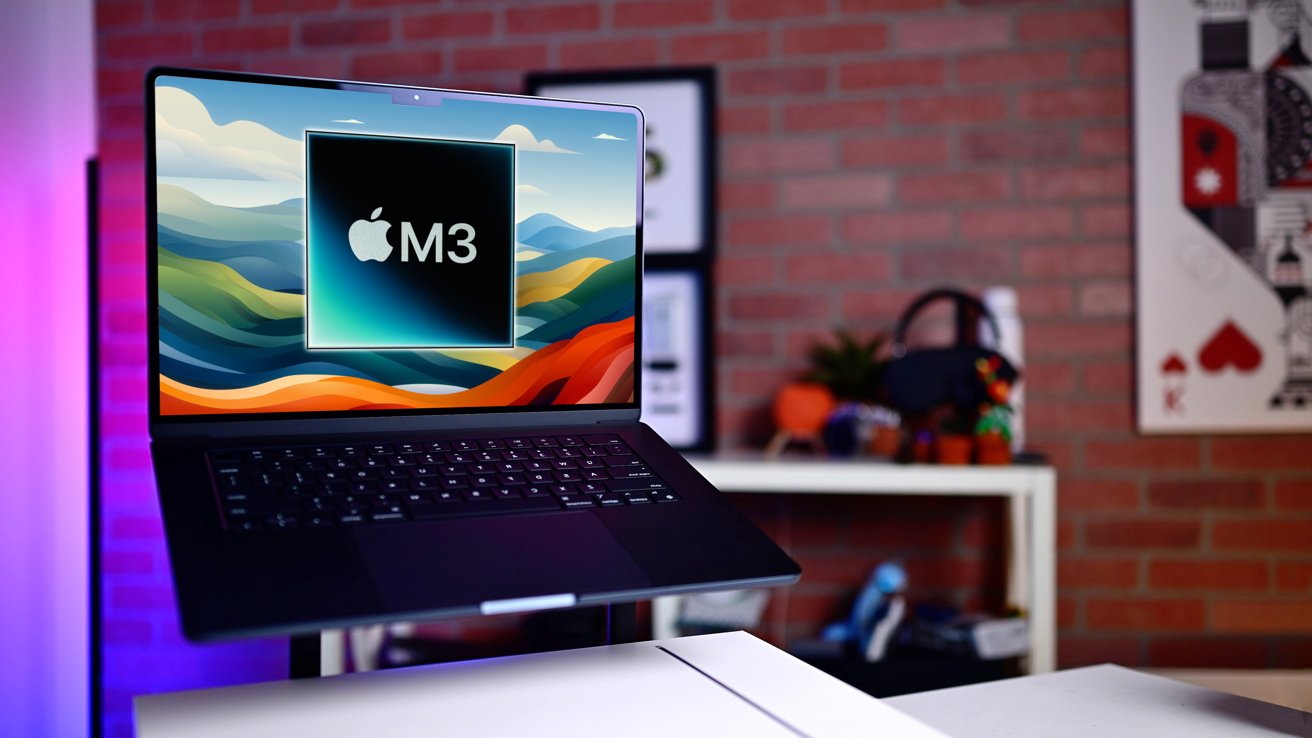 M3 MacBook Air na stole s grafikou s logem Apple a „M3“ na stylizovaném pozadí s barevnou policí a cihlovou zdí v pozadí.