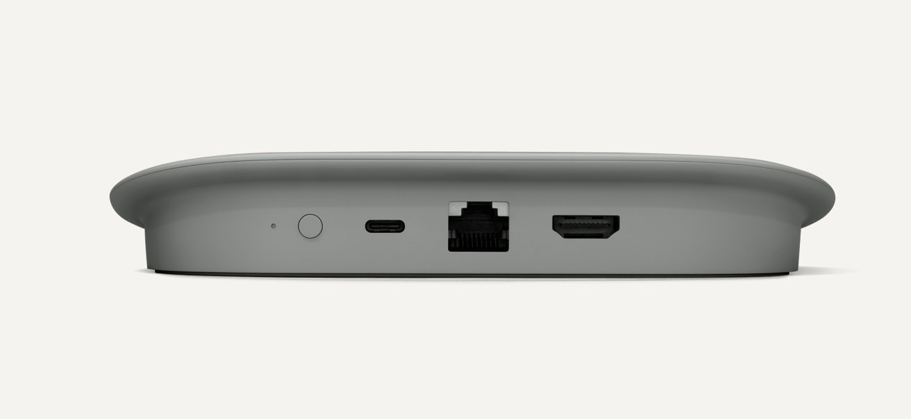 Malé šedé elektronické zařízení s porty včetně vypínače, USB-C, Ethernetu a slotů HDMI.