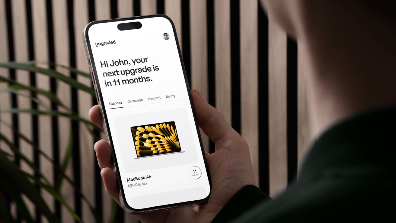 Osoba držící iPhone zobrazující zprávu o upgradu za 11 měsíců s možnostmi zařízení, pokrytím, podporou a fakturací a obrázkem MacBooku Air.