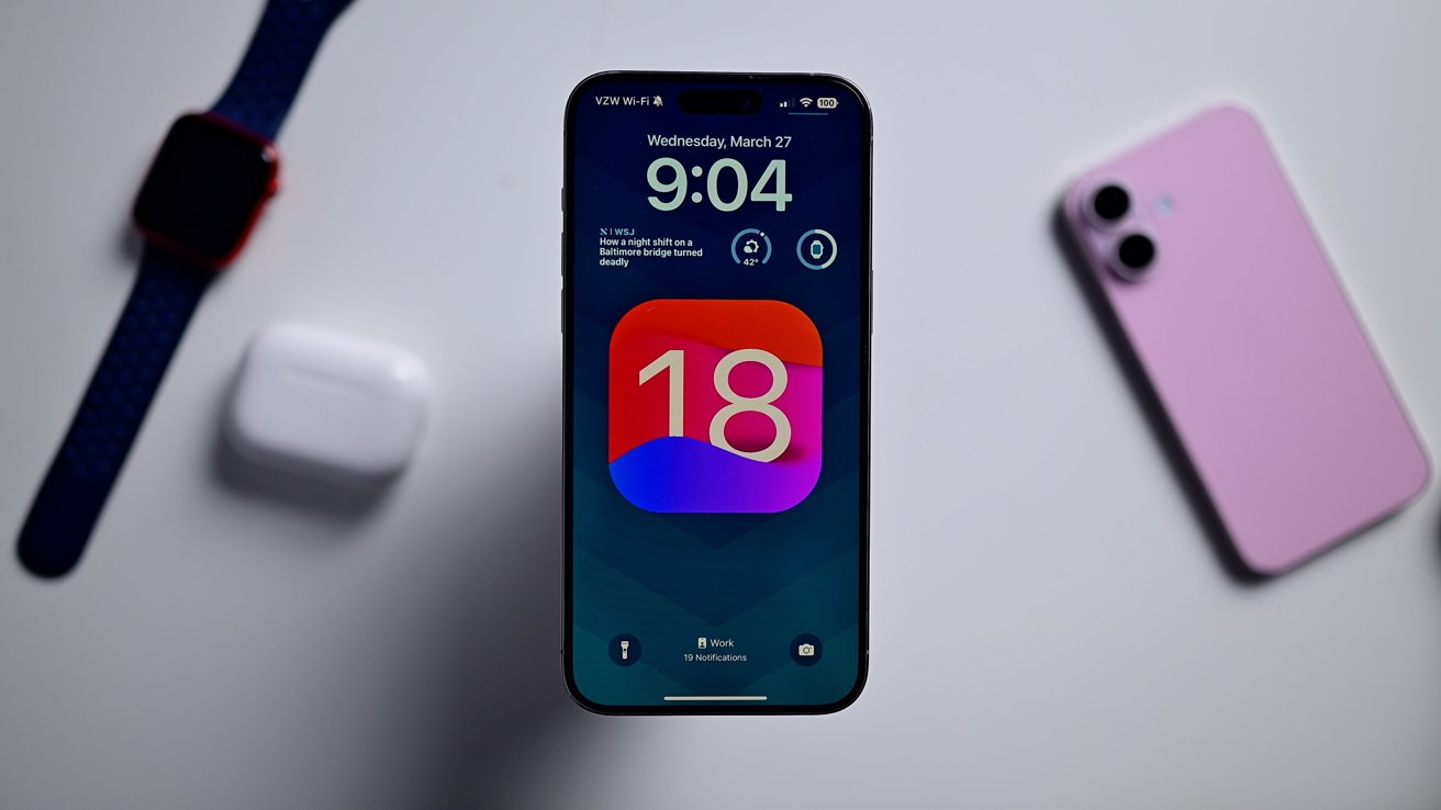 iPhone na bílém stole s obrazovkou aktualizace iOS 18