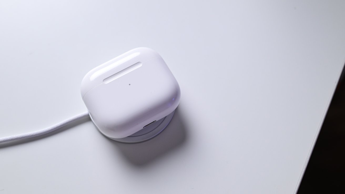 Sada AirPods umístěná na nabíjecím puku MagSafe