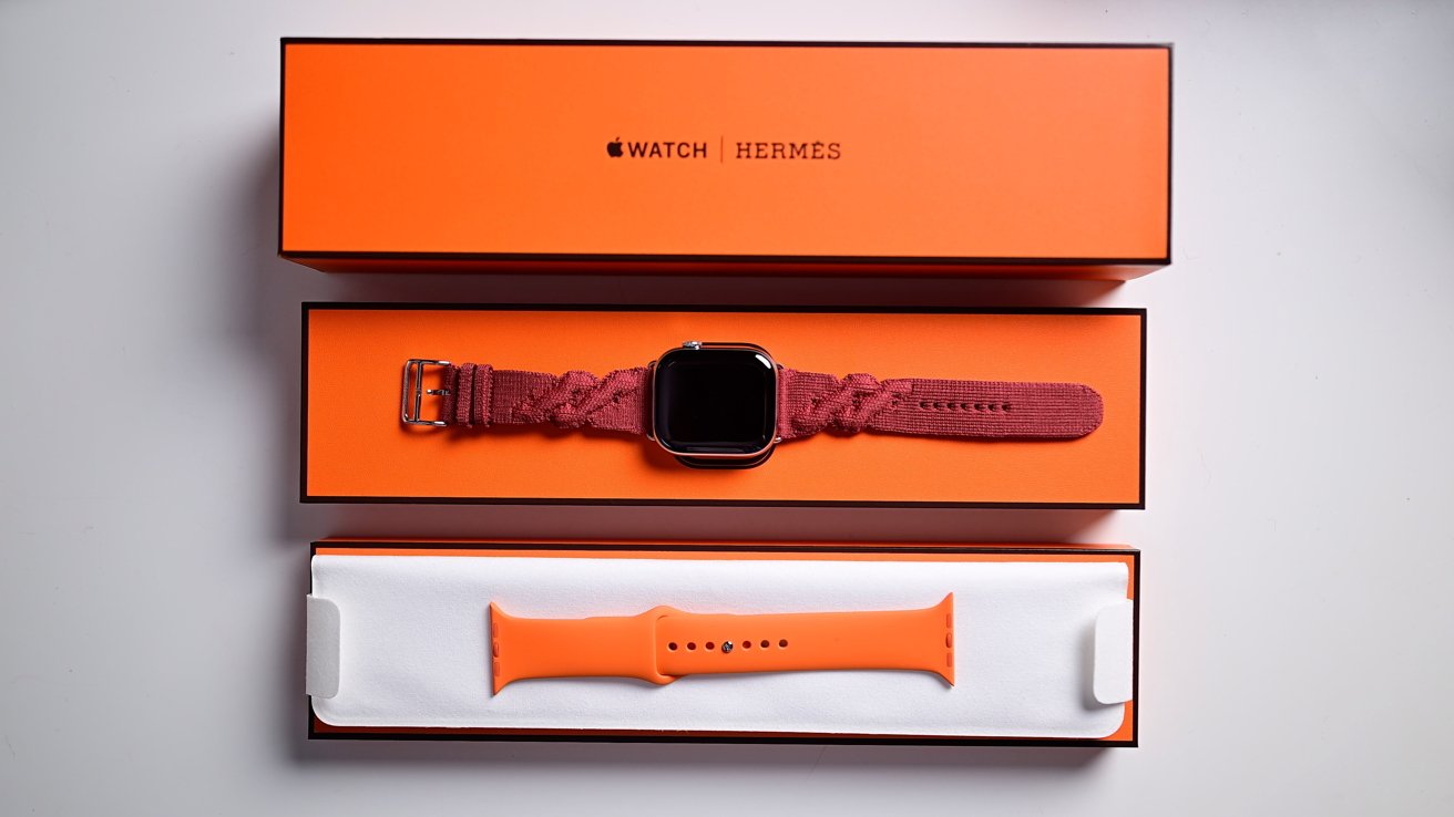 Všechny krabice a části Hermes Apple Watch rozložené na stole